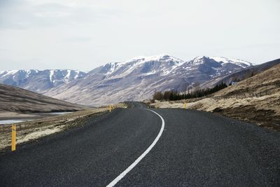 Scenic view of road by mountains against sky