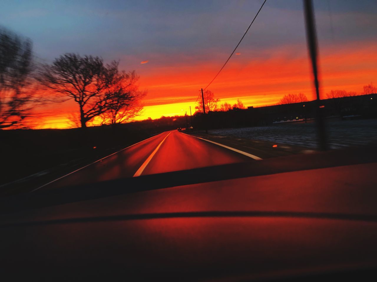 SUNSET SEEN THROUGH CAR WINDSHIELD