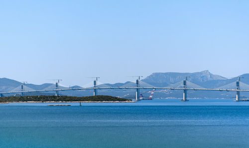 Sailboats in sea against clear blue sky