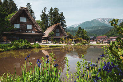 Scenic view of lake by buildings against sky