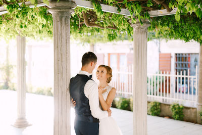 Full length of couple standing against wall