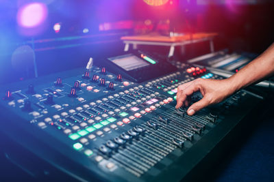 Cropped hand of person playing sound mixer at music concert
