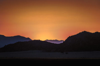 Scenic view of silhouette mountains against sky during sunset