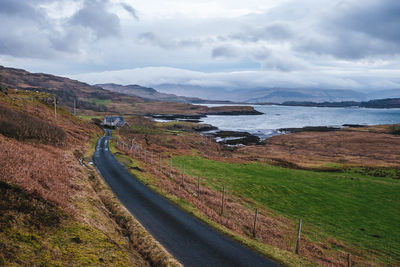 Scenic view of road by mountains against sky