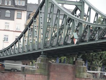 Bridge over road amidst buildings in city