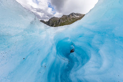 Low angle view of ice formation against cloudy sky