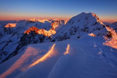 Scenic view of snow covered mountains during sunset