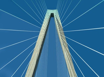 Low angle view of suspension bridge against blue sky