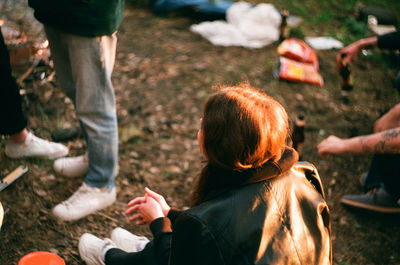 Rear view of people sitting on field