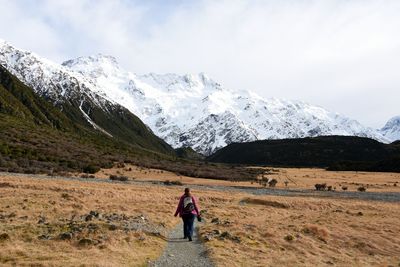 Rear view of woman walking on mountain during winter