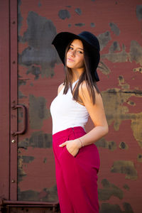 Young woman standing against wall