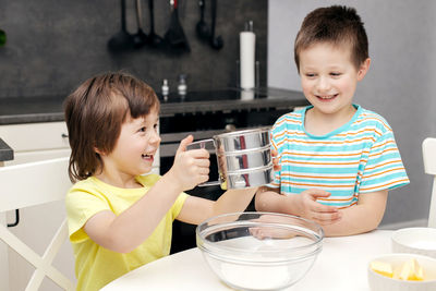 Children prepare dough in the kitchen. the boys cook at home. time with children at home. 