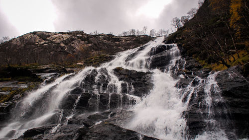 Scenic view of waterfall against sky