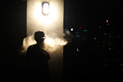 Silhouette man smoking at night