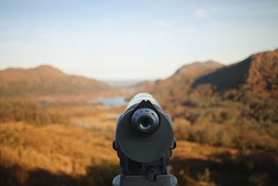 Man photographing on mountain against sky