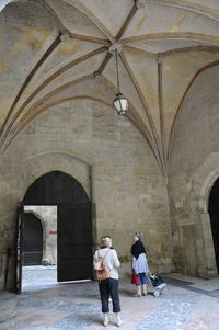 Rear view of people walking in historical building