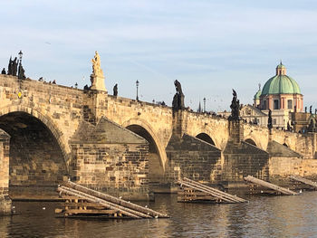 Bridge over river against buildings in city