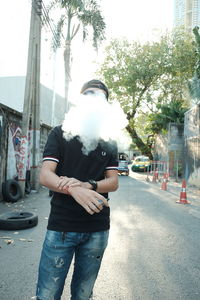 Man smoking on street in city