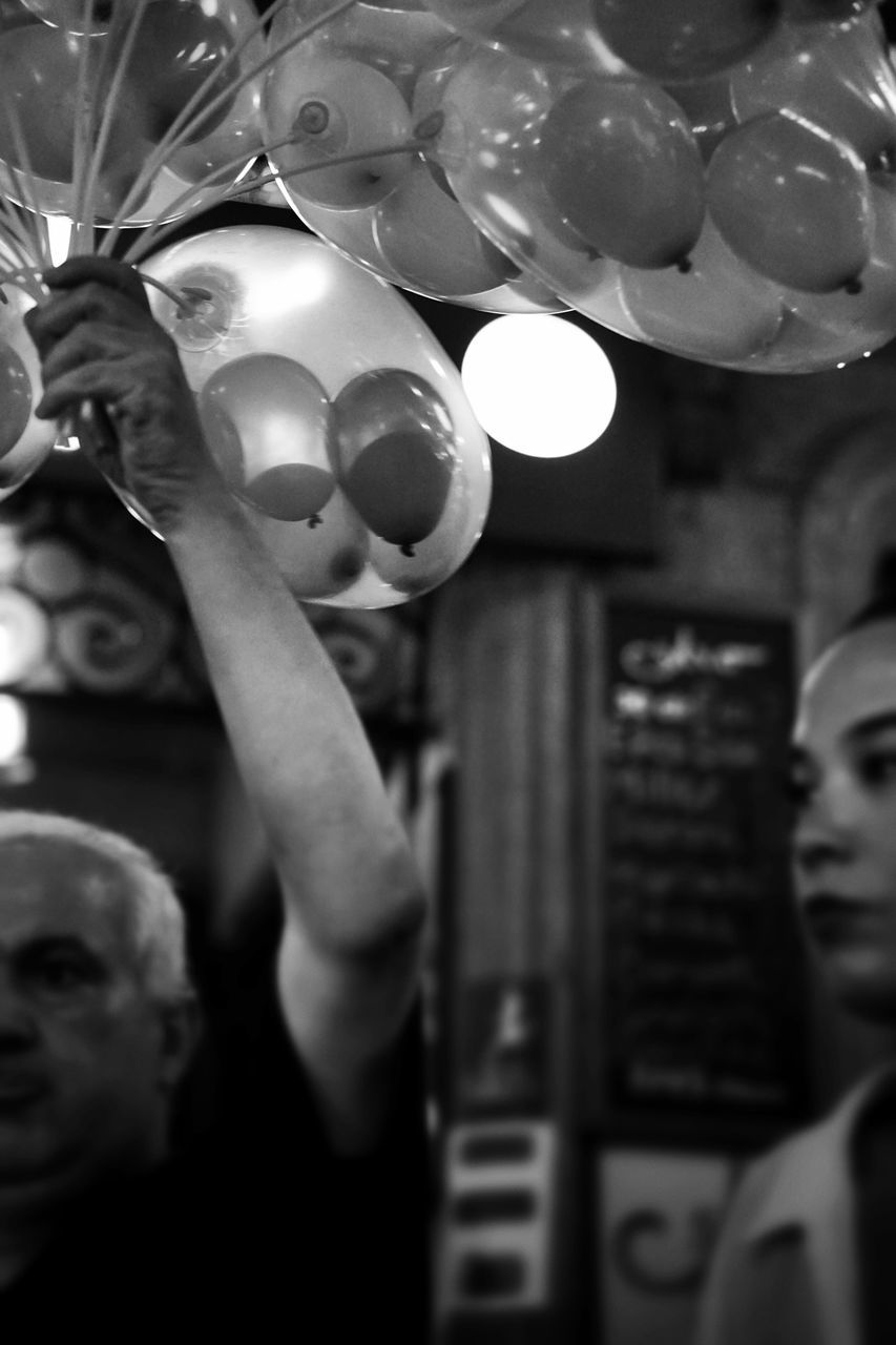 indoors, lifestyles, leisure activity, men, holding, person, close-up, focus on foreground, part of, food and drink, glass - material, selective focus, illuminated, unrecognizable person, cropped, large group of objects