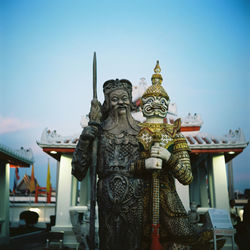 Statue of temple against building and sky