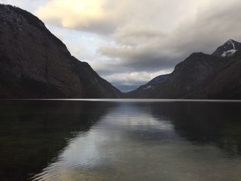 Scenic view of lake by mountains against sky