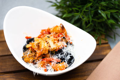 Deep bowl with seafood pasta, tomato sauce and freshly grated parmesan cheese