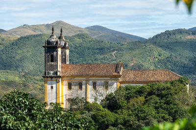 Traditional building by mountains against sky