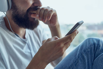 Midsection of man using mobile phone