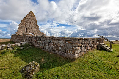 Historic old ruins of saint birgitta chapel on grass against sky