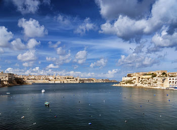 Scenic view of sea by buildings against sky