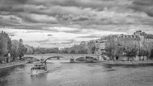 Bridge over river in city against sky