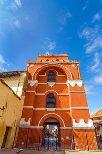 Low angle view of arco torre del carmen against blue sky