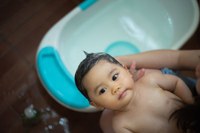 Portrait of cute baby boy in bathroom