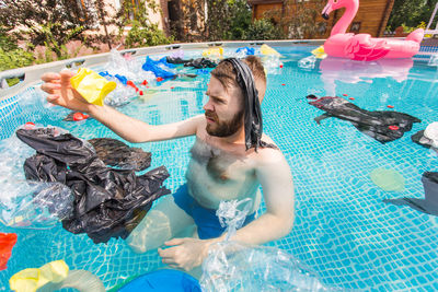 High angle view of shirtless man in swimming pool