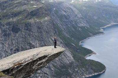 Man standing on rock by mountains