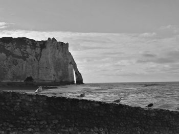 Scenic view of sea and cliff at etretat against sky
