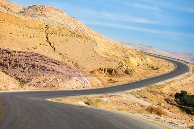 Road by mountain against sky