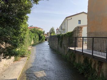 Empty road amidst buildings against sky