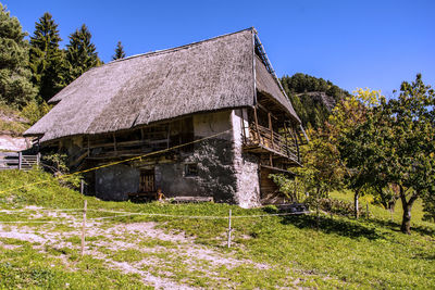 House by trees against clear sky