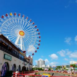 Low angle view of ferris wheel against buildings in city