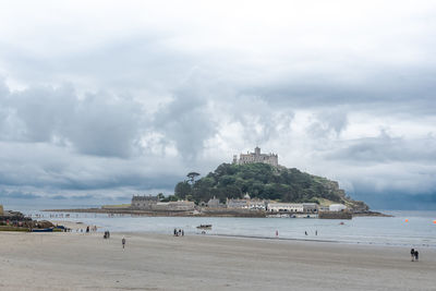 Scenic view of beach against cloudy sky