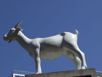 Low angle view of statue against clear blue sky