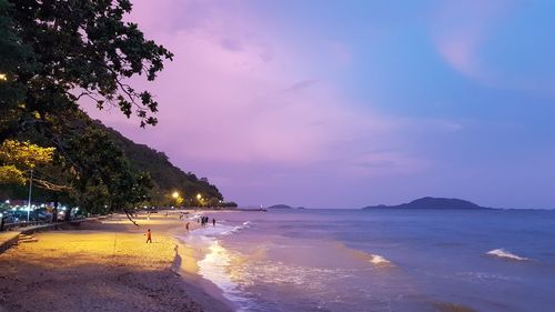 Scenic view of beach against sky at sunset