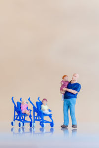 Full length of father with toy standing against white background