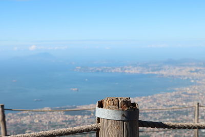 Wooden post with sea in background against sky