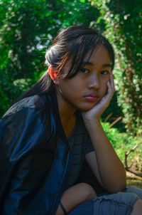 Portrait of young woman sitting outdoors