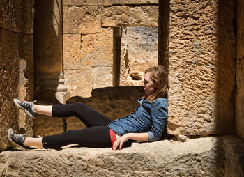 Full length of woman sitting outdoors