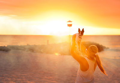 Woman standing at beach during sunset