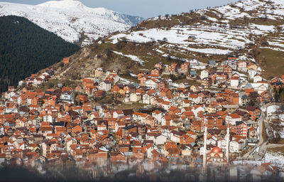 Aerial view of townscape against snowcapped mountain