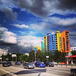 Traffic on road against cloudy sky